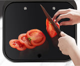 Black tempered glass cover of the sink used as a cutting surface